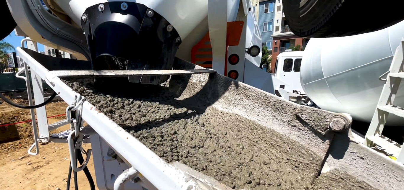 Concrete mixer truck pouring fresh concrete for residential project