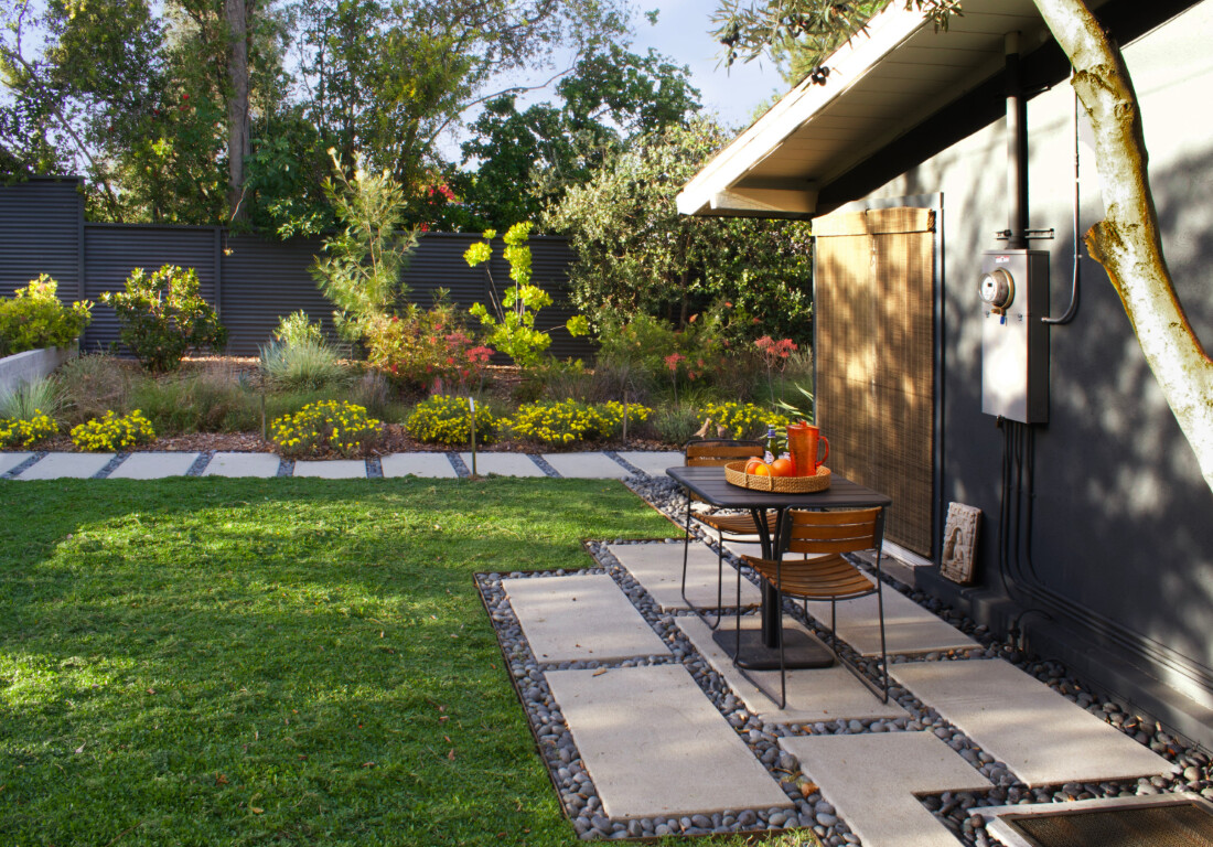 Modern concrete patio with decorative stepping stones and outdoor furniture
